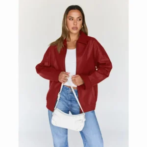 Woman wearing a red leather jacket with a white crop top, blue jeans, and a white shoulder bag for a casual chic outfit.