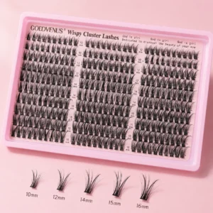 DIY lash extensions wispy cluster lash tray with individual fishtail lash clusters in multiple lengths on a soft pink background.