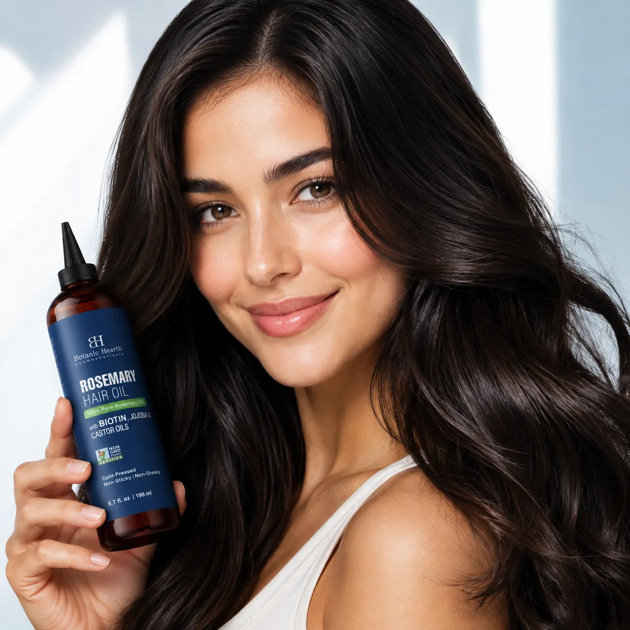 Beauty model holding hair growth oil with thick, shiny, healthy-looking hair in a premium commercial portrait.
